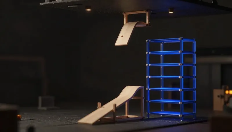 A miniature overflowing single-lane chute beside a taller glowing blue modular rack with room to expand, showing outgrowing Zapier, not automation itself.
